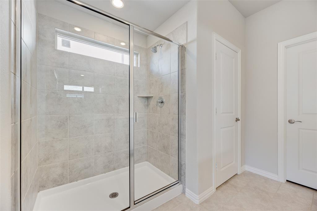 203 Rocky Road Melissa, TX 75454 - Photo 16 of 27 a bathroom with a shower and a glass door
