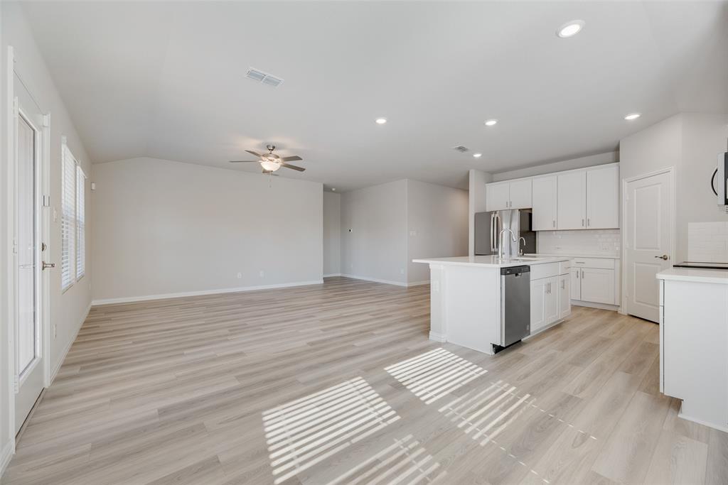 203 Rocky Road Melissa, TX 75454 - Photo 6 of 27 a view of a kitchen with wooden floor and electronic appliances