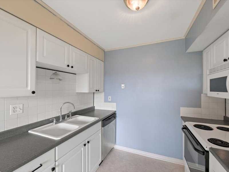 26 Cooper Road, Unit 306 Poughkeepsie, NY 12603 - Photo 11 of 16 a kitchen with granite countertop a sink stove and cabinets