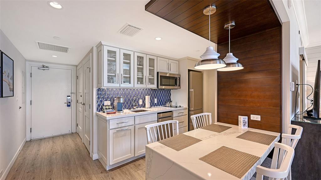 240 Sands Point Road, Unit 4206 Longboat Key, FL 34228 - Photo 15 of 41 a open kitchen with stainless steel appliances kitchen island a stove a sink dishwasher and a refrigerator with wooden floor