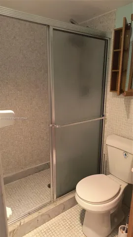 a bathroom with a toilet and a shower