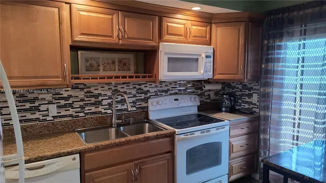 a kitchen with granite countertop a stove top oven microwave and cabinets