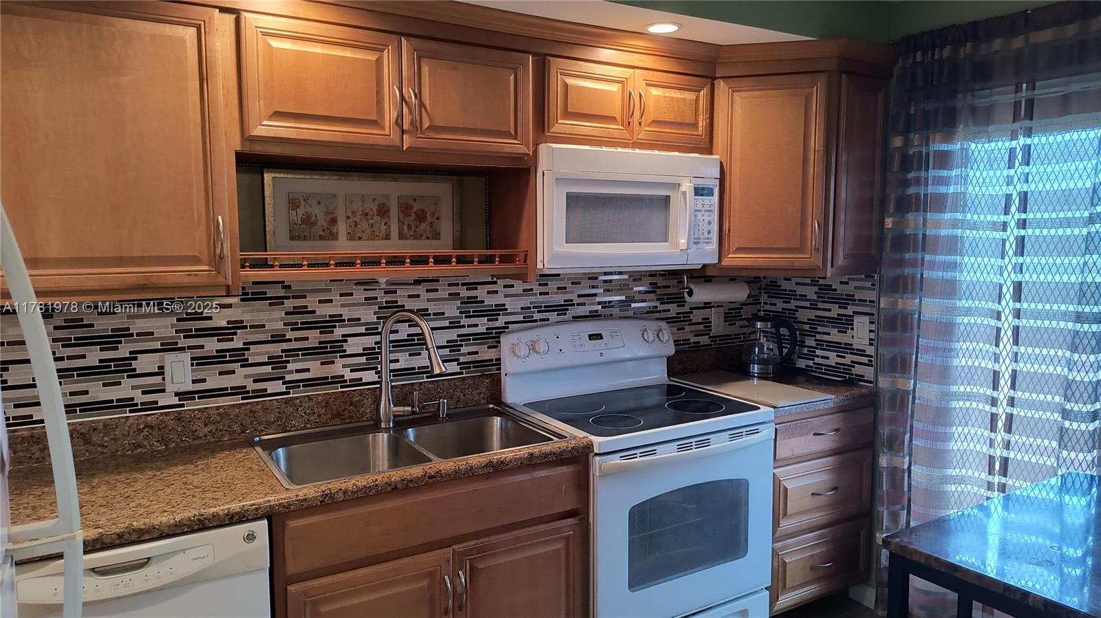4500 North Federal Highway, Unit 352F Lighthouse Point, FL 33064 - Photo 5 of 32 a kitchen with granite countertop a stove top oven microwave and cabinets