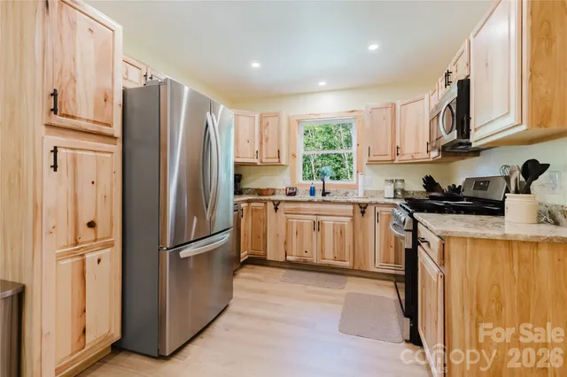 a kitchen with stainless steel appliances granite countertop a refrigerator sink and cabinets