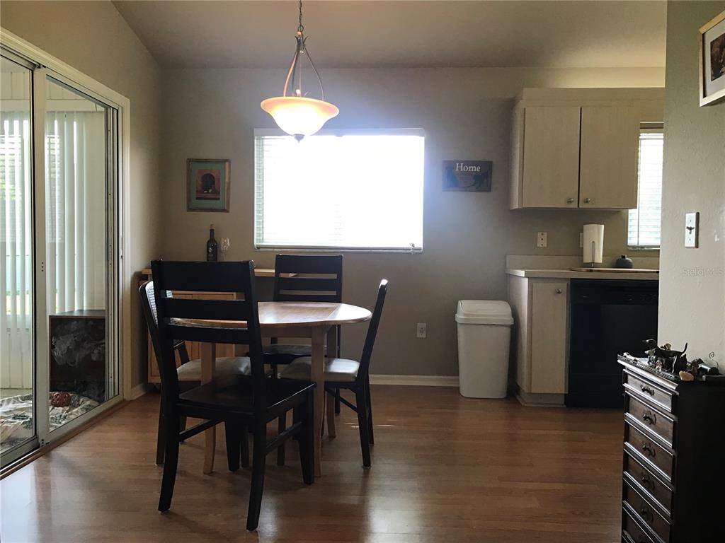 11879 Southwest 137th Loop Dunnellon, FL 34432 - Photo 22 of 37 a kitchen with stainless steel appliances granite countertop a stove a sink dishwasher a dining table and chairs with wooden floor