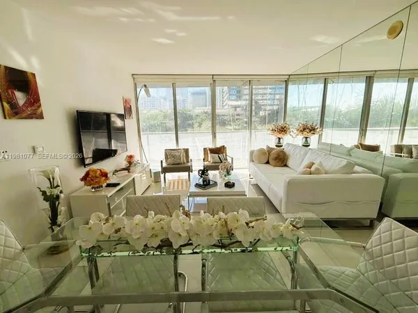 a living room with furniture large window and a flat screen tv