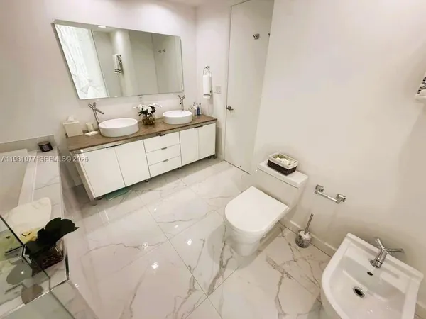 a bathroom with a sink mirror and toilet