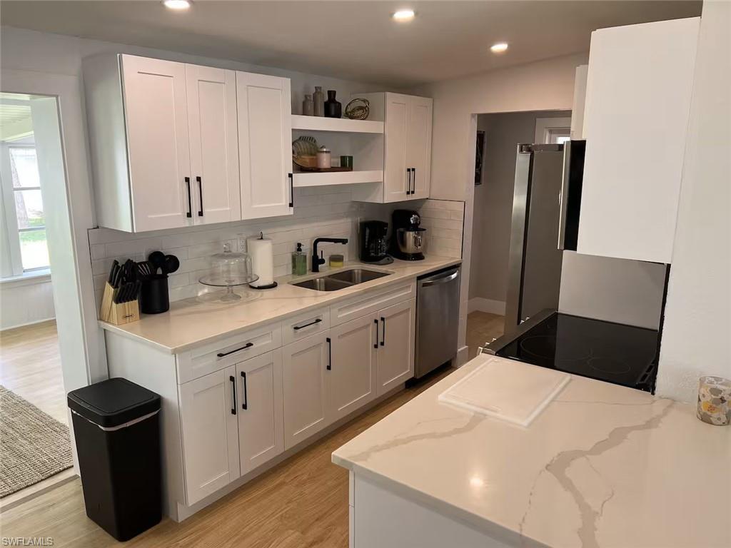1220 Embassy Lane Naples, FL 34104 - Photo 11 of 11 a kitchen with a refrigerator a stove top oven a sink and cabinets