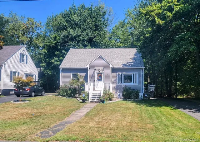 a front view of a house with a yard and trees