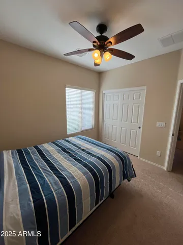 a bedroom with a bed and a ceiling fan
