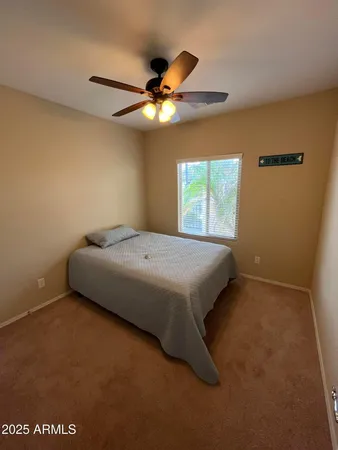 a bedroom with a bed and a ceiling fan
