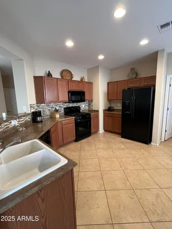 a kitchen with stainless steel appliances a stove a sink a microwave a refrigerator and a refrigerator
