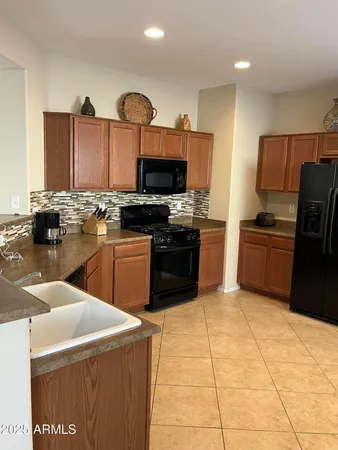 a kitchen with stainless steel appliances granite countertop a stove top oven a sink a counter top space and cabinets