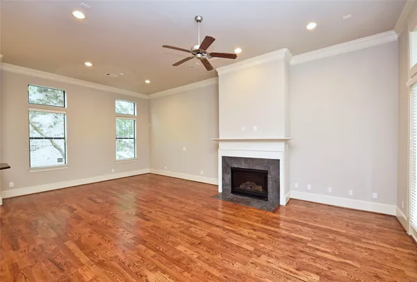 an empty room with large windows and fireplace