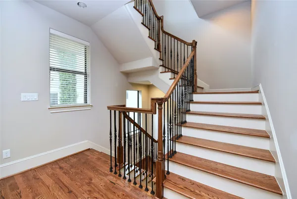 a view of a hallway with wooden floor and stairs