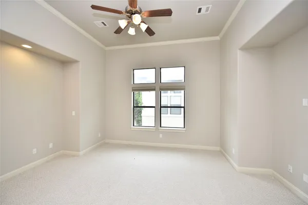 an empty room with closet and a ceiling fan