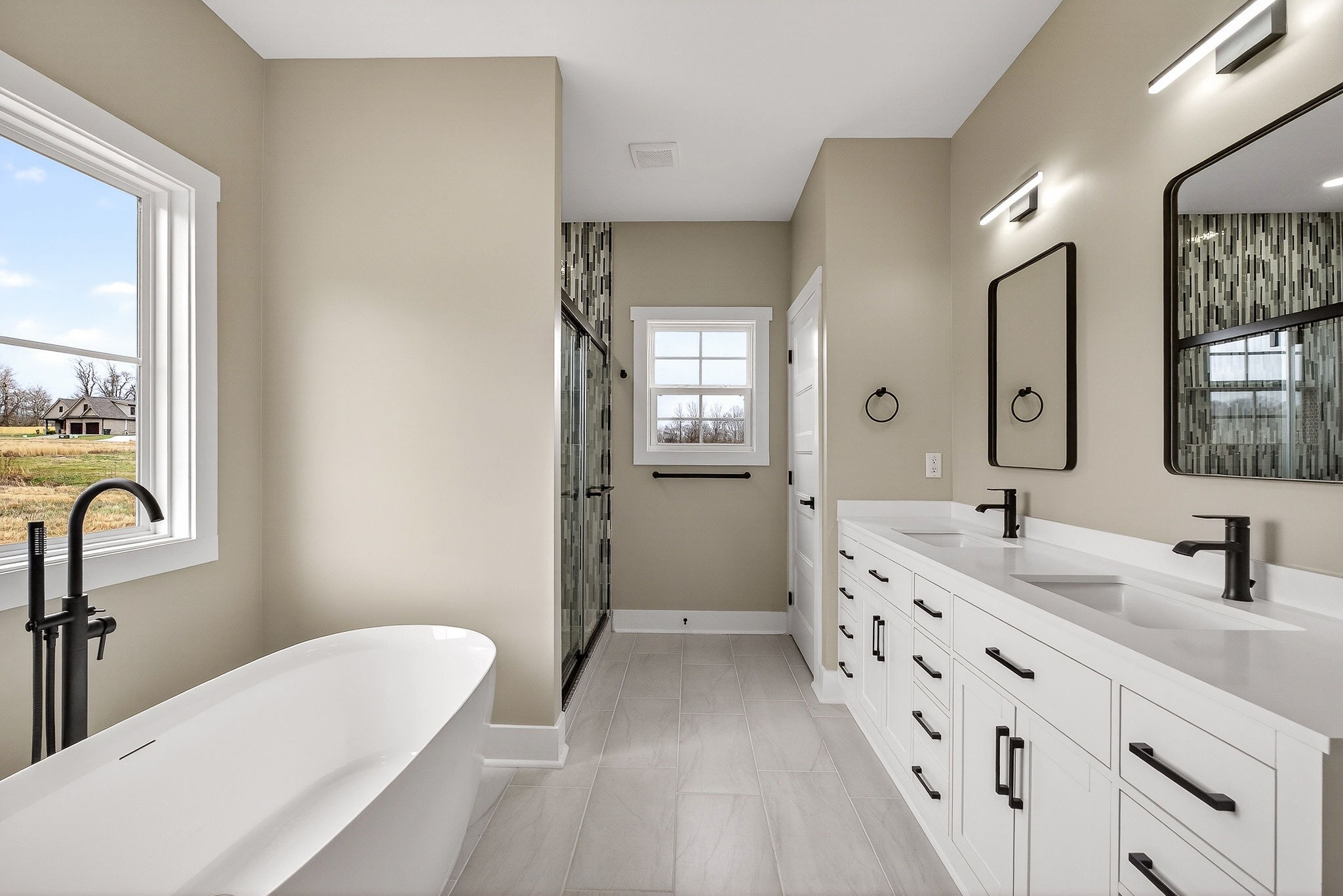 6955 Sweet Magnolia Way Baxter, TN 38544 - Photo 12 of 53 a bathroom with a double vanity sink a mirror a bathtub and window