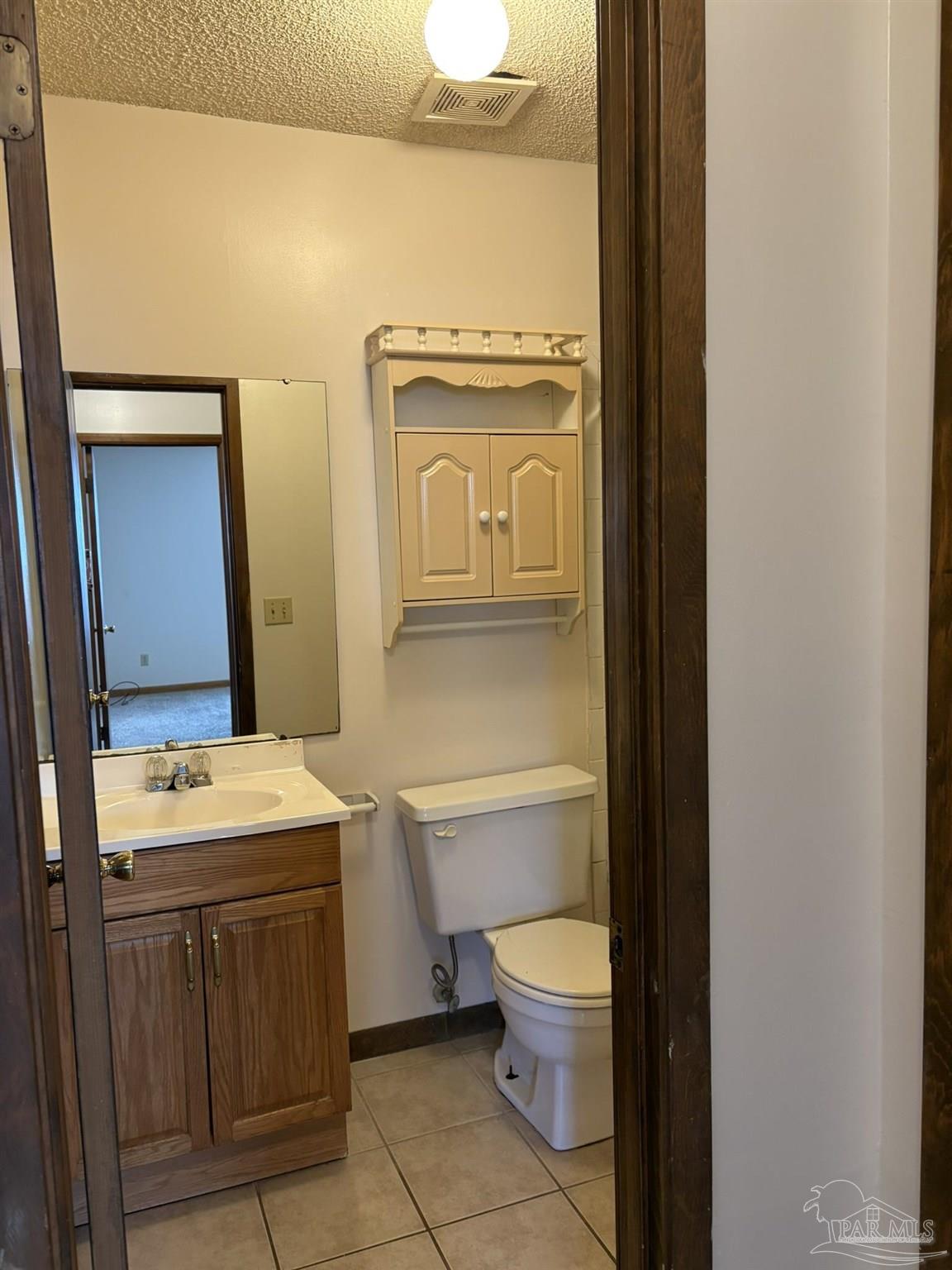 3262 Maplewood Drive, Unit B Gulf Breeze, FL 32563 - Photo 10 of 15 a bathroom with a granite countertop toilet sink and mirror