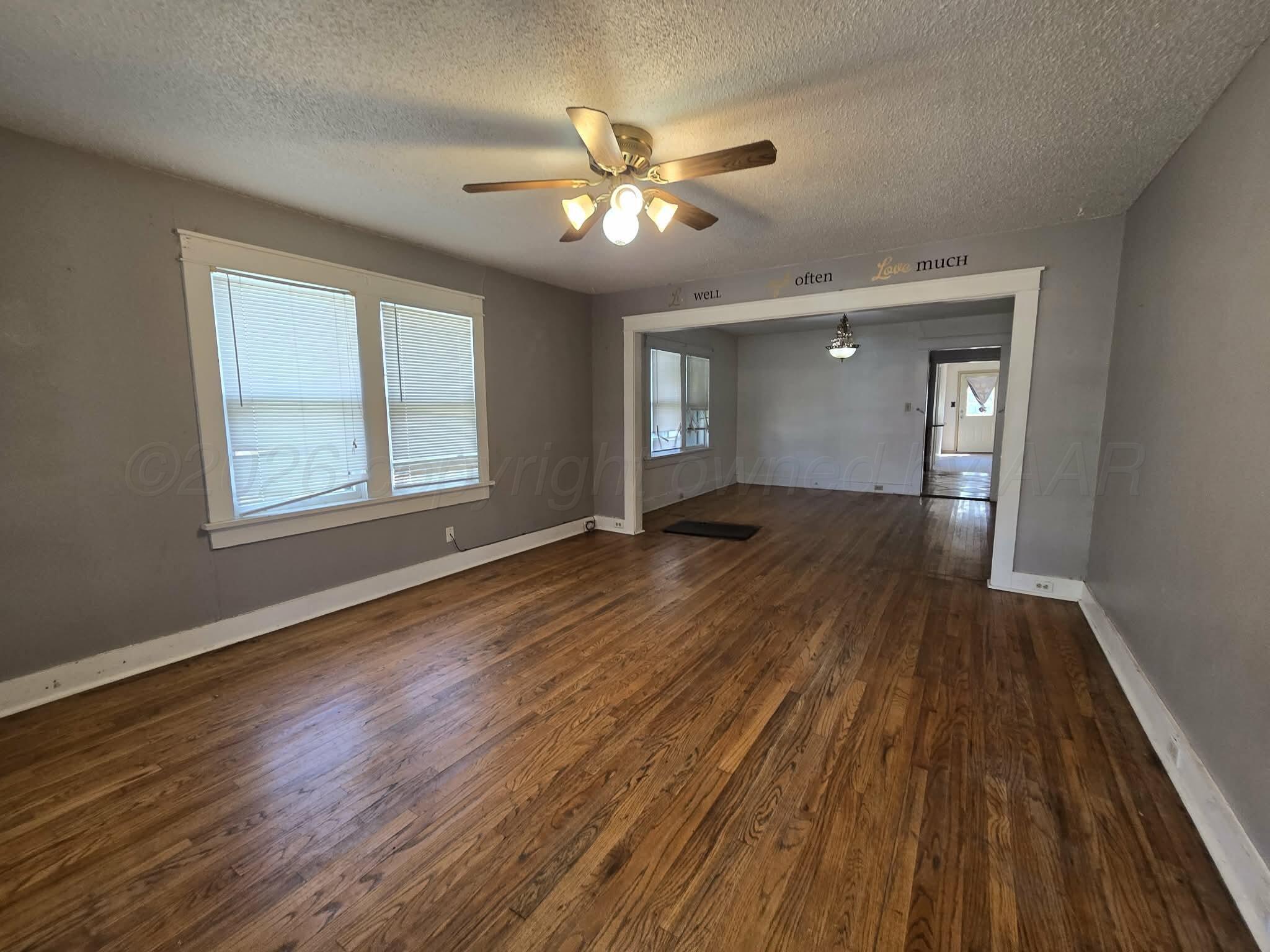 2706 Ridgemere Boulevard Amarillo, TX 79107 - Photo 2 of 49 a view of an empty room with wooden floor and a window