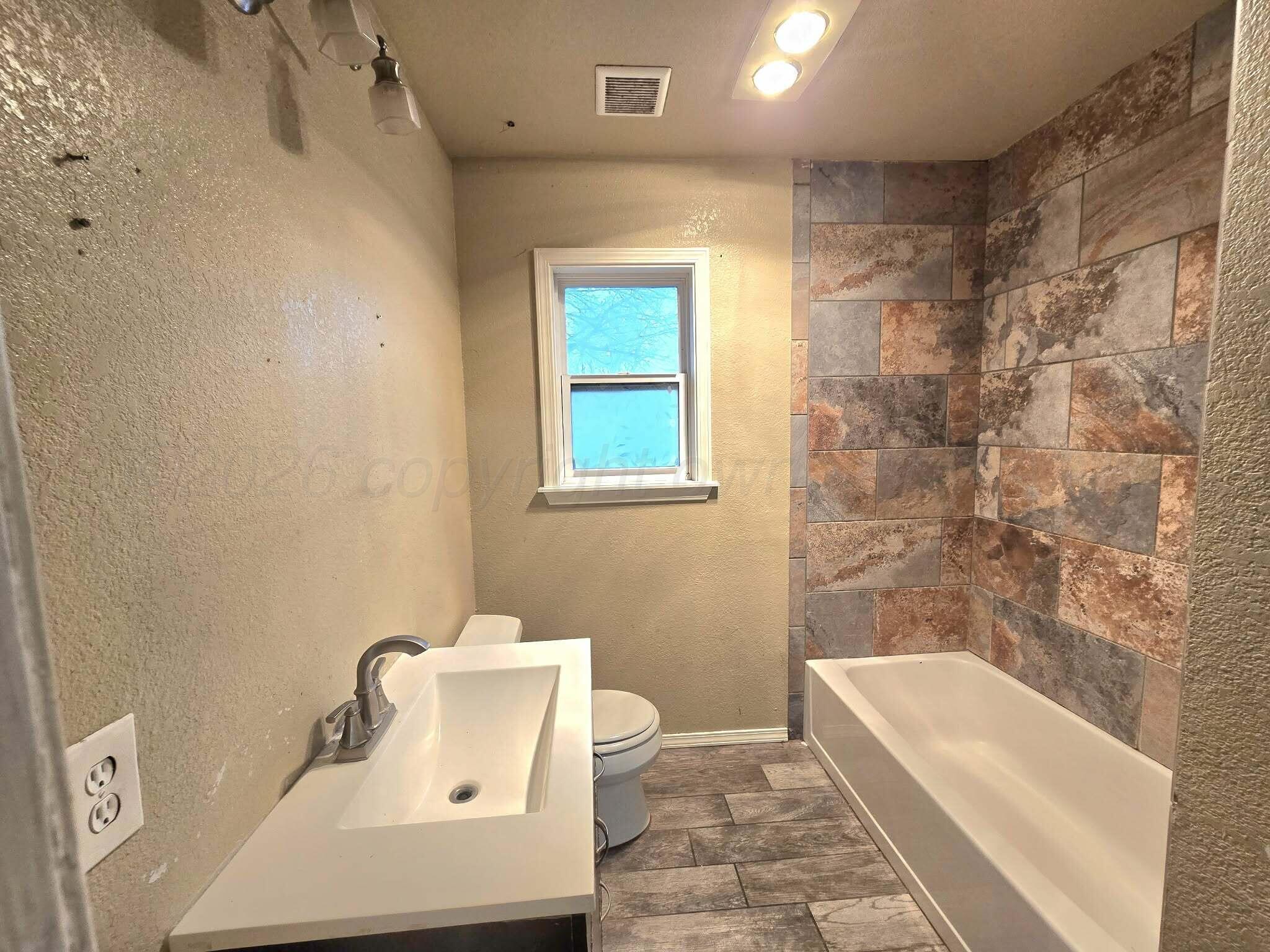 2706 Ridgemere Boulevard Amarillo, TX 79107 - Photo 22 of 49 a bathroom with a bathtub sink and toilet