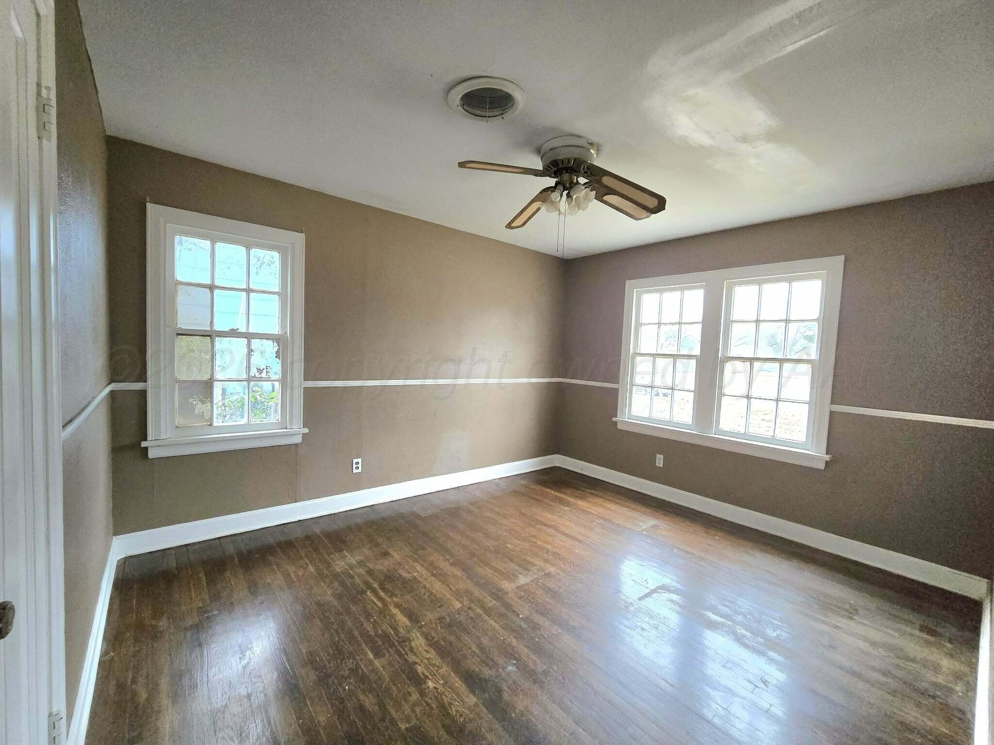 2706 Ridgemere Boulevard Amarillo, TX 79107 - Photo 28 of 49 a view of an empty room with wooden floor and a window