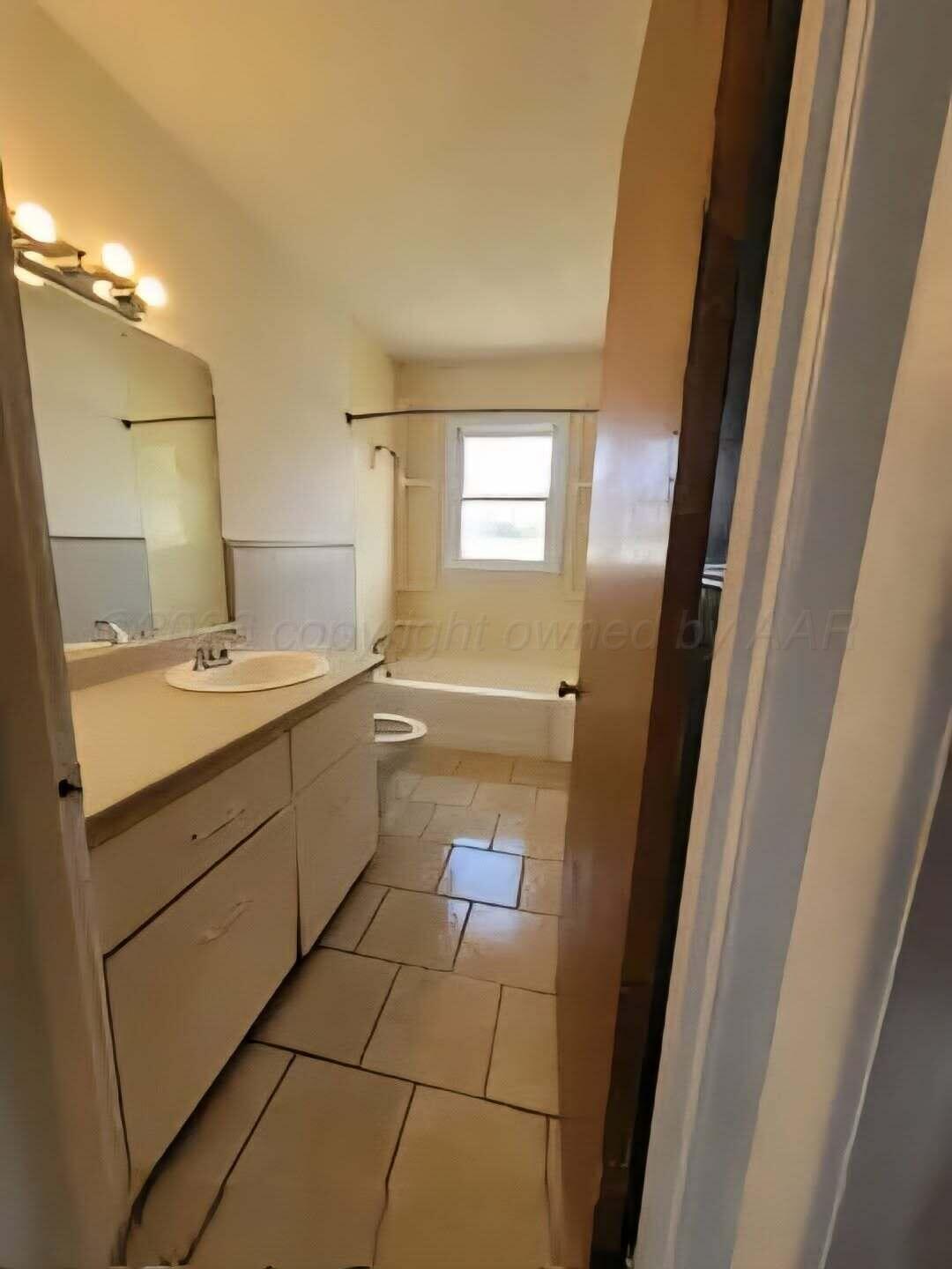 2706 Ridgemere Boulevard Amarillo, TX 79107 - Photo 38 of 49 a bathroom with a sink a toilet and mirror