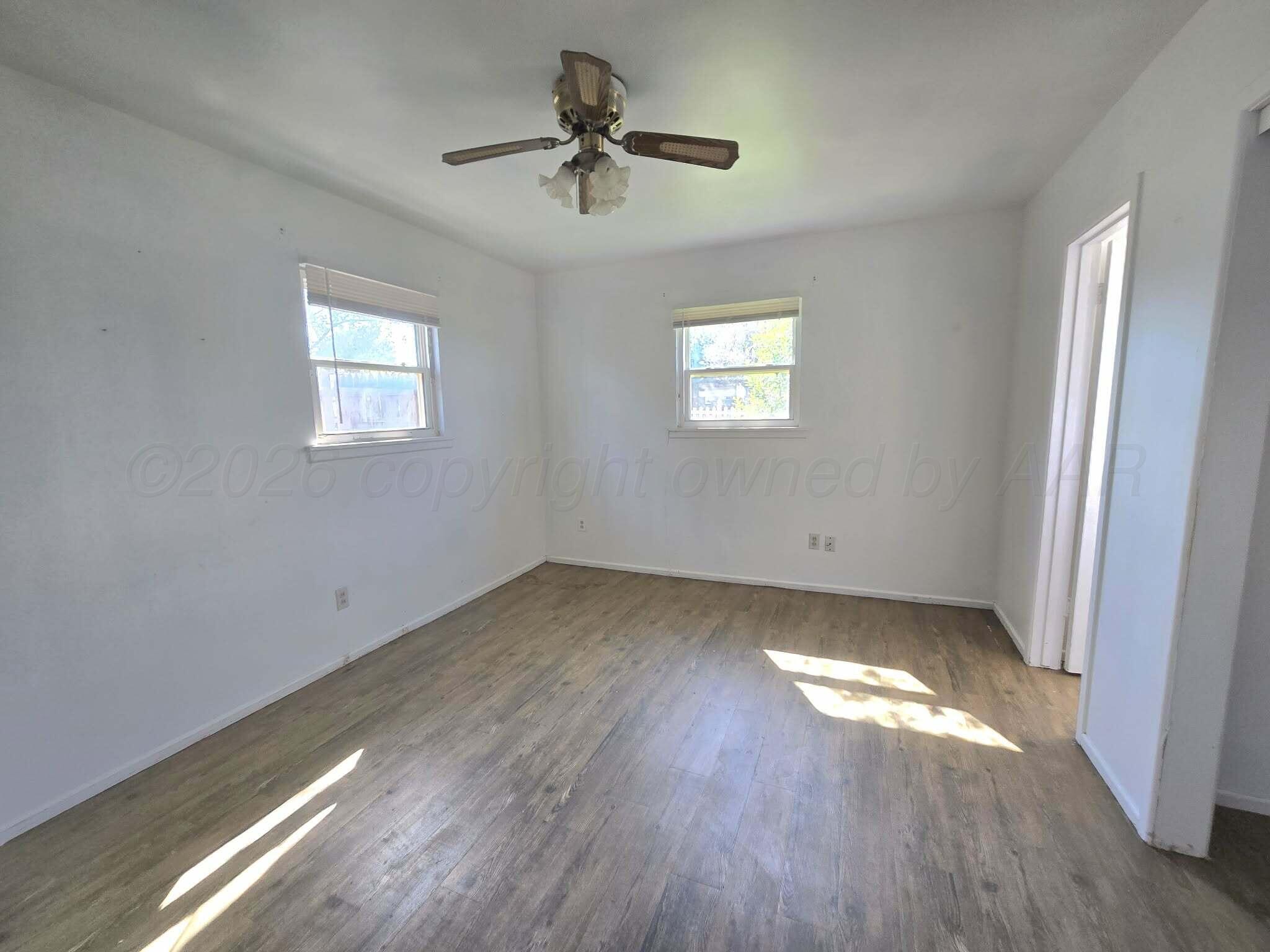 2706 Ridgemere Boulevard Amarillo, TX 79107 - Photo 44 of 49 an empty room with wooden floor fan and windows