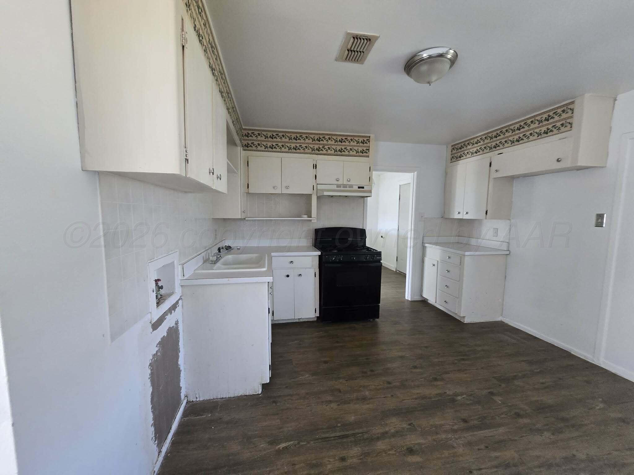 2706 Ridgemere Boulevard Amarillo, TX 79107 - Photo 45 of 49 a kitchen with cabinets a sink and white appliances