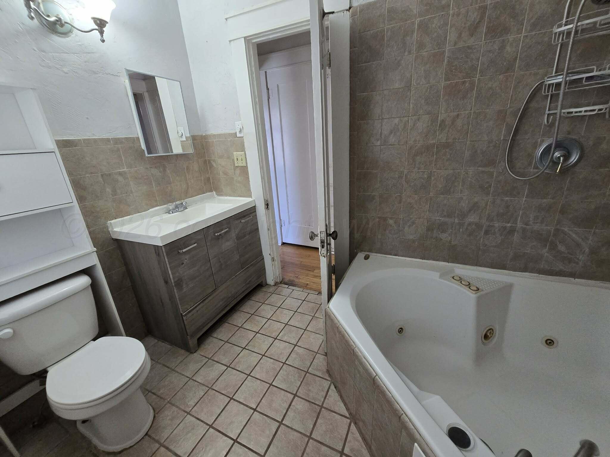 2706 Ridgemere Boulevard Amarillo, TX 79107 - Photo 5 of 49 a bathroom with a sink a toilet and mirror
