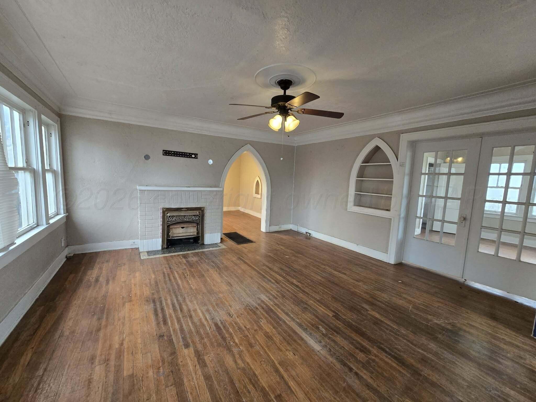 2706 Ridgemere Boulevard Amarillo, TX 79107 - Photo 10 of 49 wooden floor fireplace and windows in an empty room