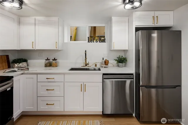a kitchen with stainless steel appliances granite countertop a refrigerator and a sink