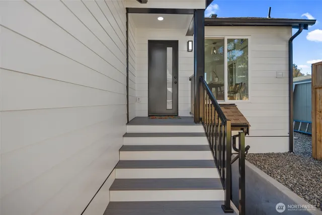 a living room with stainless steel appliances granite countertop furniture a rug a stove a sink and a window