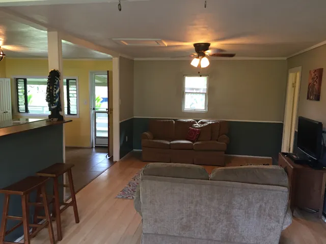 a living room with furniture a flat screen tv and a window