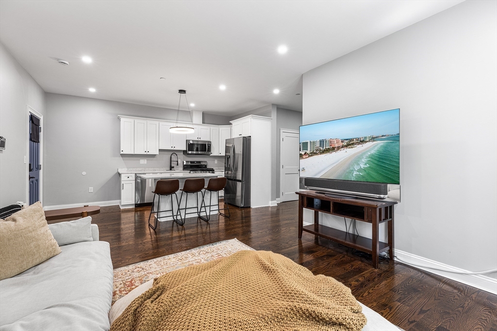 128 Hamilton Street, Unit 2B Boston, MA 02125 - Photo 12 of 23 a living room with stainless steel appliances kitchen island granite countertop furniture and a wooden floor