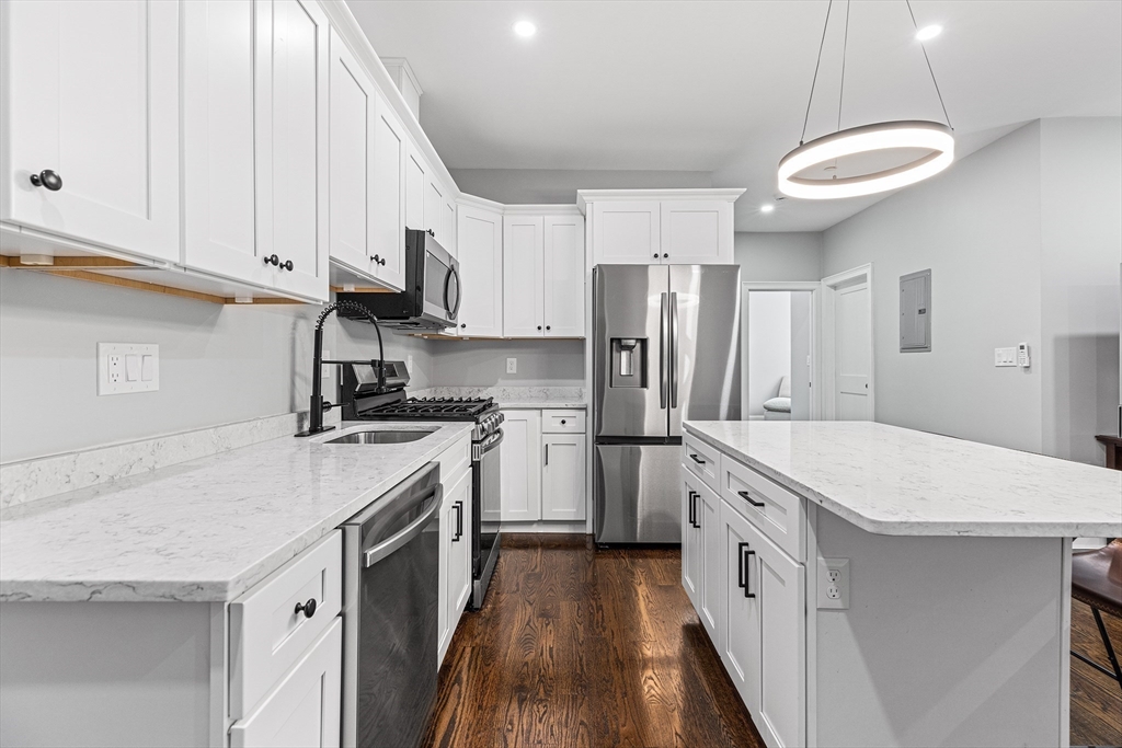 128 Hamilton Street, Unit 2B Boston, MA 02125 - Photo 3 of 23 a kitchen that has a lot of white cabinets and stainless steel appliances