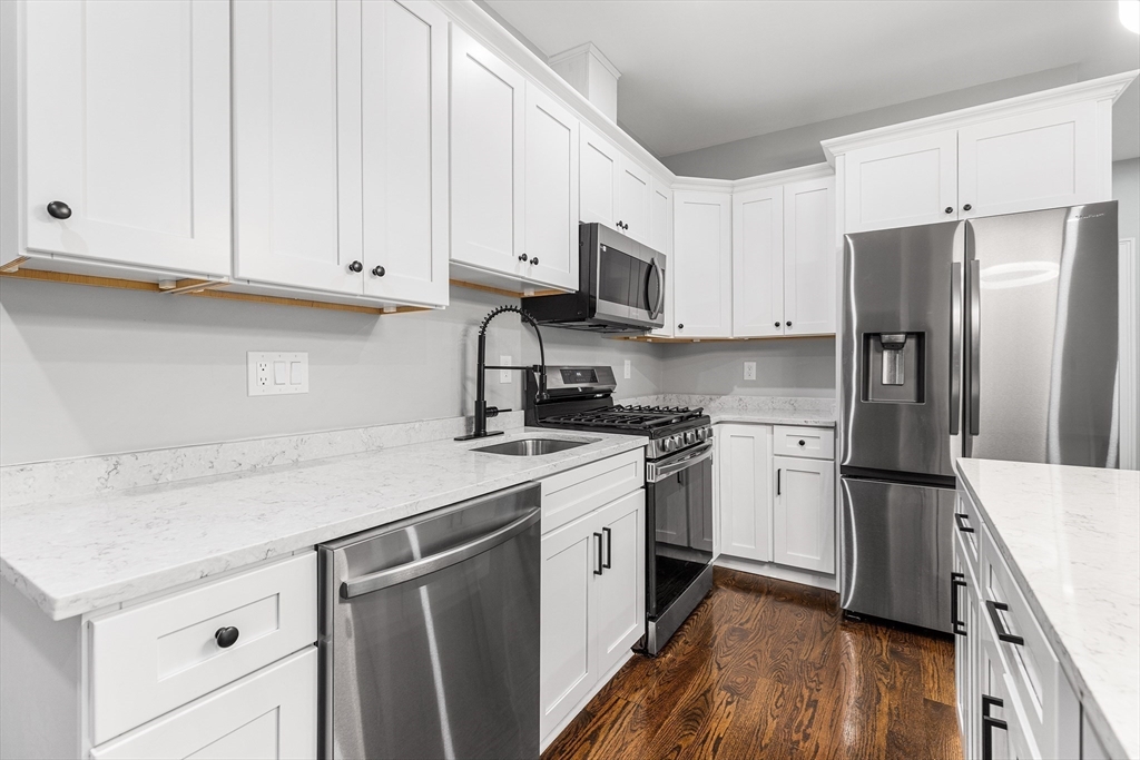 128 Hamilton Street, Unit 2B Boston, MA 02125 - Photo 4 of 23 a kitchen with stainless steel appliances granite countertop a refrigerator sink and white cabinets