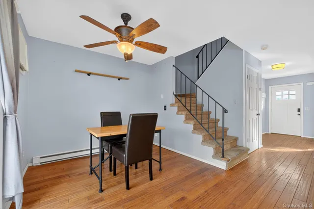 a view of a livingroom with wooden floor and a ceiling fan