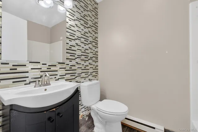 a bathroom with a sink a toilet and mirror