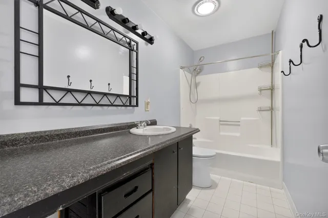 a bathroom with a granite countertop sink a toilet and a mirror