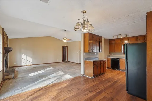 a kitchen with stainless steel appliances granite countertop a refrigerator a sink dishwasher a stove with wooden cabinets and floor