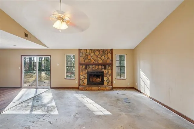 a view of an empty room with a fireplace and a large window