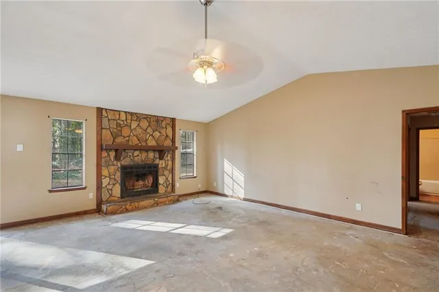 a view of an empty room with a fireplace and a window