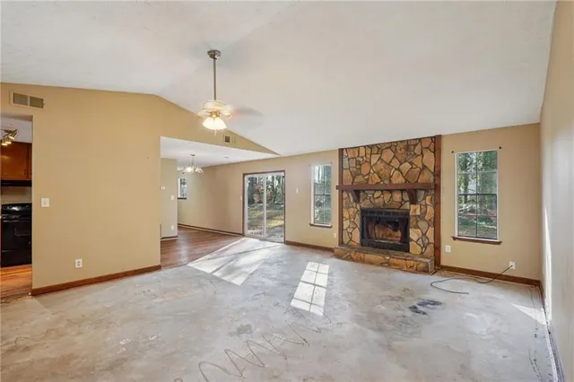 a view of an empty room with a fireplace and a window