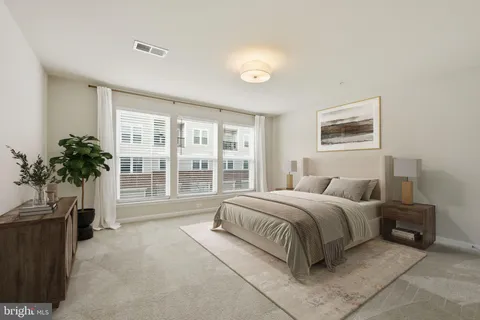 a spacious bedroom with a large bed and a potted plant