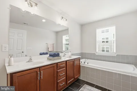 a bathroom with a tub sink and mirror