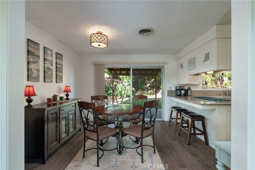 398 Day Road Ventura, CA 93003 - Photo 17 of 69 a view of a dining room and livingroom with furniture wooden floor a rug a potted plant and a chandelier