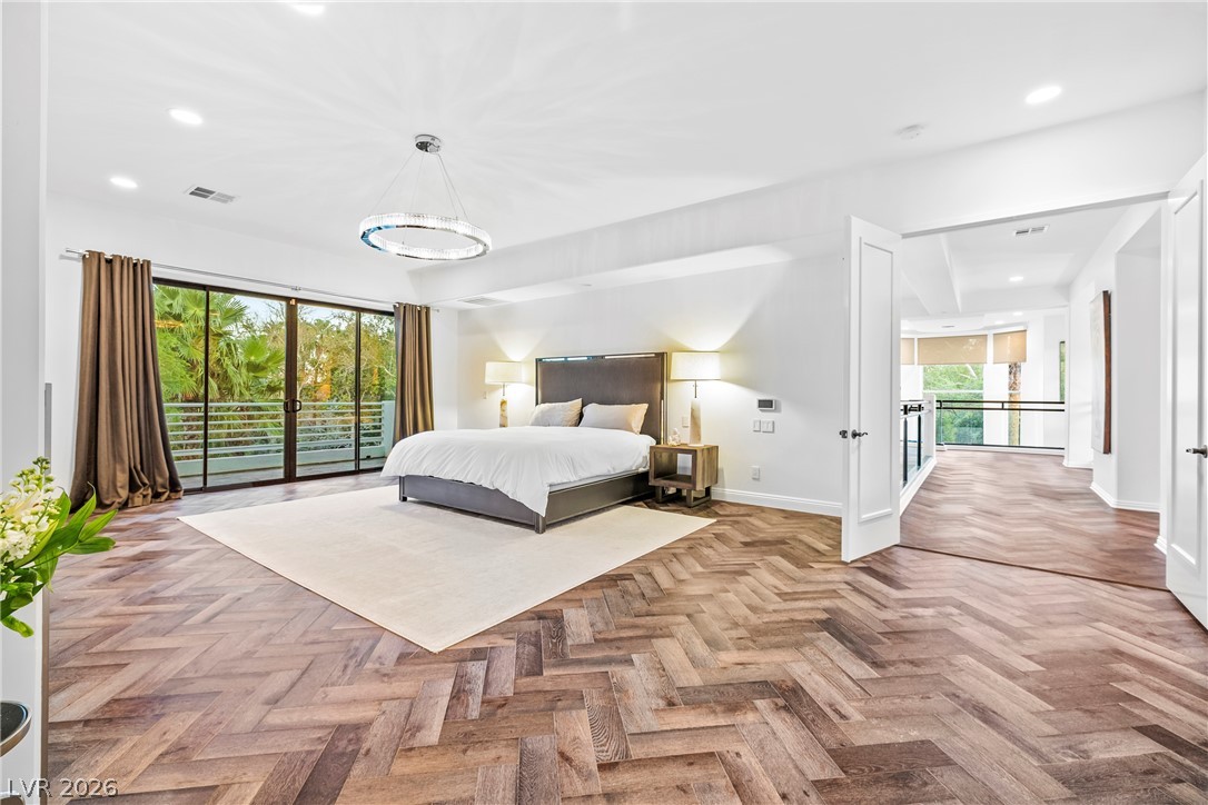 2000 Grouse Street Las Vegas, NV 89134 - Photo 39 of 89 Herringbone hardwood floors extend through this generously proportioned sleeping area, leading to a balcony with lush outdoor views.