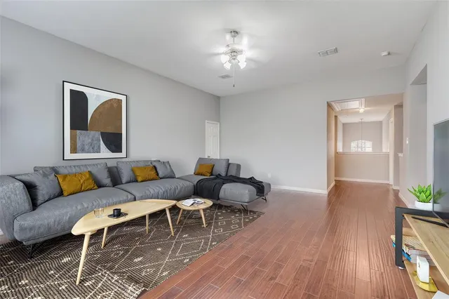 a living room with furniture and wooden floor
