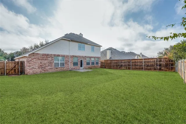 a view of a house with a big yard and large trees