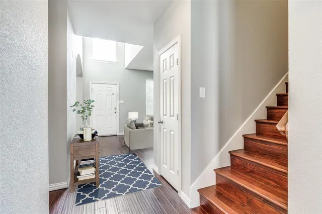 a view of a hallway with wooden floor and a living room
